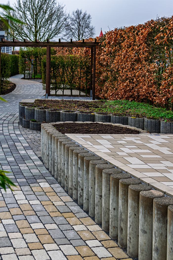 Aangelegde klinkerbestrating met een keerwand van betonnen palen