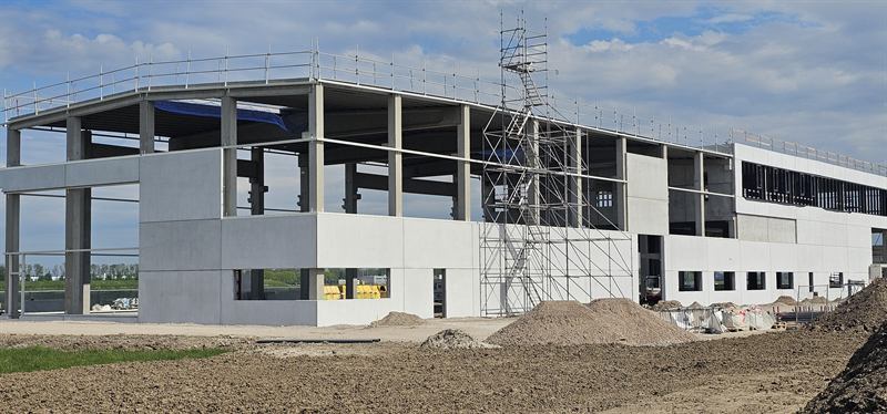 Betonnen casco met steigerwerk van een bedrijfspand in aanbouw
