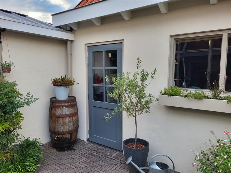 Aangelegd terras met gebakken klinkers en beplanting in potten